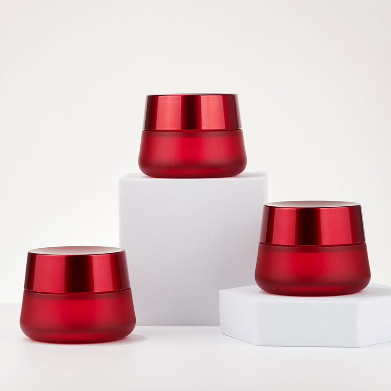 丸い化粧品の赤いクリームの瓶空のガラスのクリームの瓶