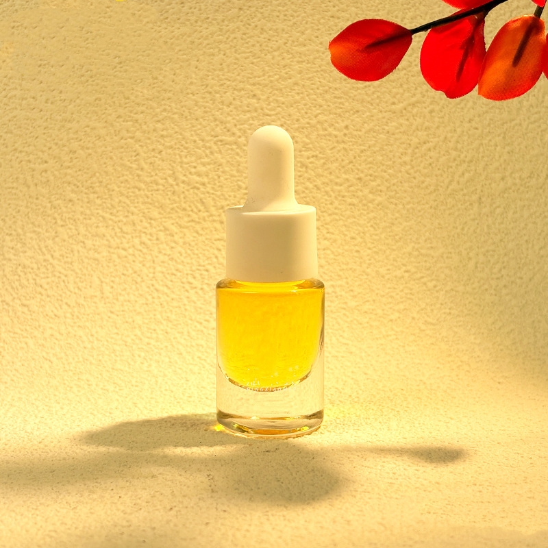 金属または木製のドロッパーが付いている小さなガラスのエッセンシャル オイルのボトル